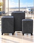 Three charcoal grey textured suitcases displayed at an airport