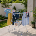 Foldable wing clothes drying rack with clothes and laundry hanging outdoors