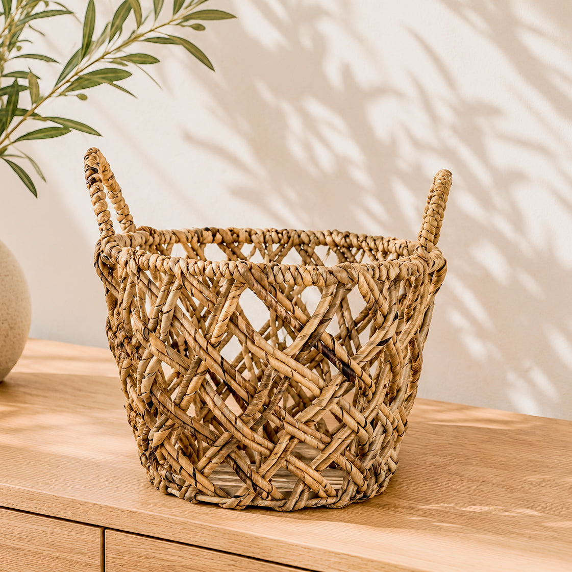 Round woven storage basket with integrated handles for organizing towels, clothing, toys, books, magazines, and household essentials.